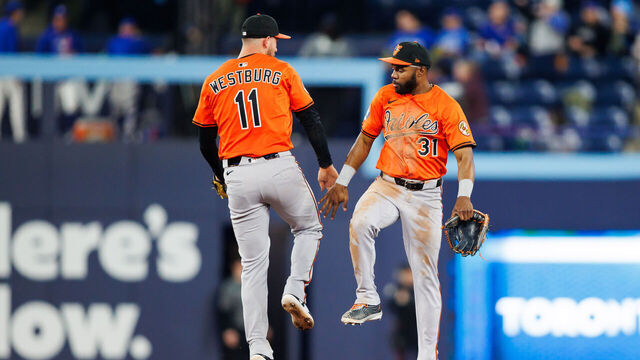 TORONTO, CANADA - MARCH 29: Jordan Westburg #11 and Cedric Mullins #31 of the Baltimore Orioles celebrate at in the outfiedl at the end of their MLB game against the Toronto Blue Jays at Rogers Centre on March 29, 2025 in Toronto, Ontario, Canada.