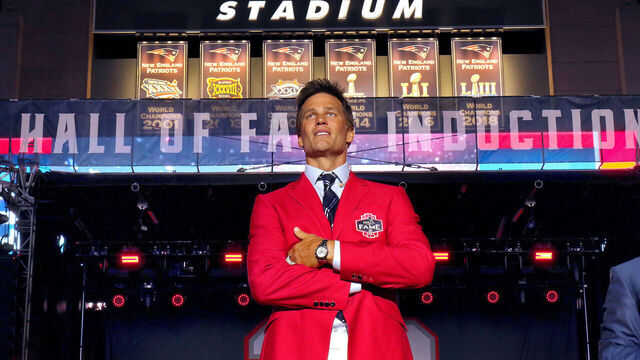 Foxborough-06/12/2024 Tom Brady, Former New England Patriots quarterback, stands center stage under looming Super Bowl banners as he receives a standing ovation at the end of his Patriots Hall of Fame induction ceremony. (John Tlumacki/The Boston Globe via Getty Images)