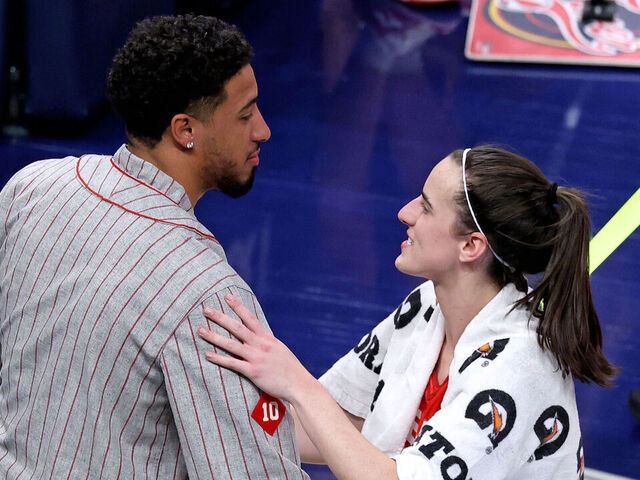 INDIANAPOLIS, IN - AUGUST 16: Indiana Fever guard Caitlin Clark (22) talks to Indiana Pacer guard Tyrese Haliburton after defeating the Phoenix Mercury at Gainbridge Fieldhouse on August 16, 2024 in Indianapolis, Indiana.