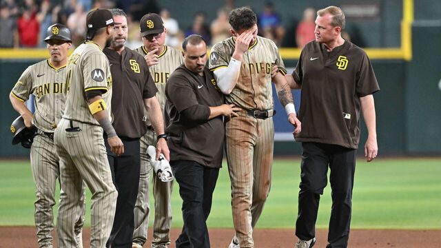 PHOENIX, AZ - JUNE 14: Jackson Merrill #3 of the San Diego Padres is escorted off the field after being tagged in the head while stealing second base in the seventh inning during the game between the San Diego Padres and the Arizona Diamondbacks at Chase Field on Saturday, June 14, 2025 in Phoenix, Arizona.