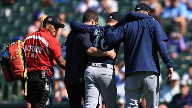 CHICAGO, ILLINOIS - JUNE 21: Trent Thornton #46 of the Seattle Mariners is helped off the field after nearly passing out while pitching during the eighth inning against the Chicago Cubs at Wrigley Field on June 21, 2025 in Chicago, Illinois.