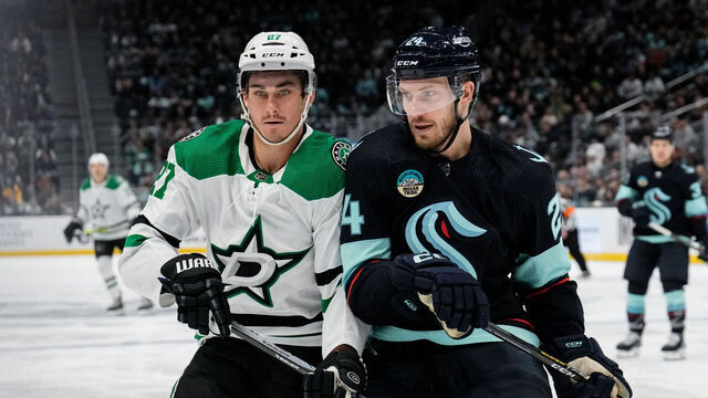 SEATTLE, WASHINGTON - MARCH 30: Mason Marchment #27 of the Dallas Stars and Jamie Oleksiak #24 of the Seattle Kraken battle for position during the third period of a game at Climate Pledge Arena on March 30, 2024 in Seattle, Washington.