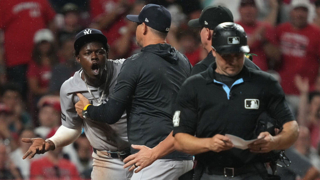 CINCINNATI, OHIO - JUNE 24: Jazz Chisholm Jr. #13 of the New York Yankees is held back by manager Aaron Boone #17 after Chisholm Jr. was ejected during the ninth inning against the Cincinnati Reds at Great American Ball Park on June 24, 2025 in Cincinnati, Ohio.