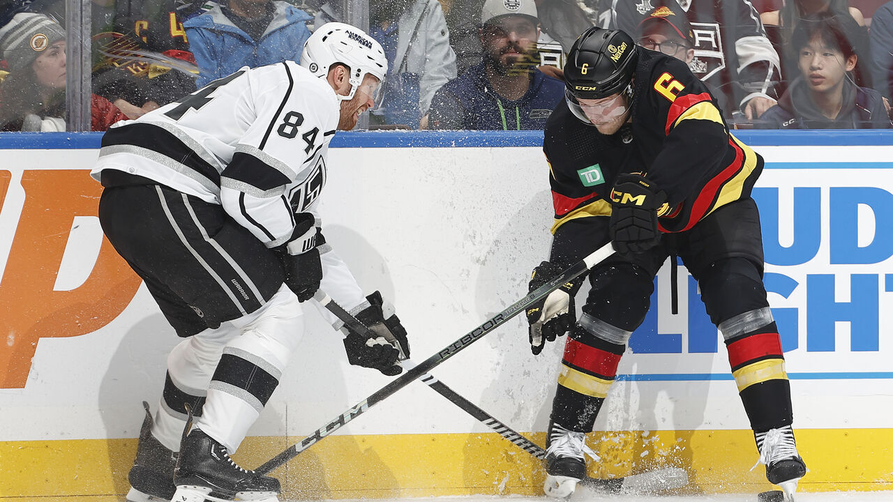 VANCOUVER, CANADA - FEBRUARY 29: Vladislav Gavrikov #84 of the Los Angeles Kings checks Brock Boeser #6 of the Vancouver Canucks during their NHL game at Rogers Arena on February 29, 2024 in Vancouver, British Columbia, Canada.
