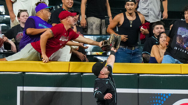 PHOENIX, ARIZONA - JUNE 30: A fan catches the ball behind Tim Tawa #13 of the Arizona Diamondbacks during the MLB game against the San Francisco Giants at Chase Field on June 30, 2025 in Phoenix, Arizona.