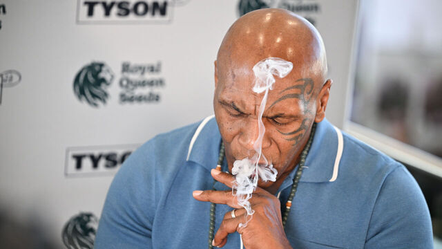 20 June 2025, Berlin: Mike Tyson, boxer and entrepreneur, smokes a joint at the Royal Queen Seeds stand at the Mary Jane cannabis trade fair. Tyson owns cannabis farms and sells his marijuana products in several US states. Photo: Sebastian Gollnow/dpa