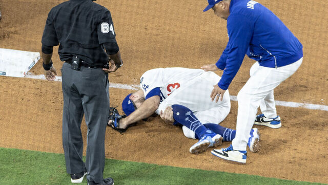 Los Angeles, CA - July 02: Los Angeles Dodgers third baseman Max Muncy lays on the ground clutching his knee after colliding with White Sox Michael A. Taylor as the Dodgers take on the Chicago White Sox at Dodger Stadium on Wednesday, July 2, 2025 in Los Angeles, CA. (Luke Johnson / Los Angeles Times via Getty Images)