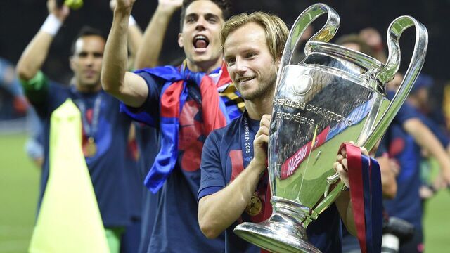 Barcelona's Croatian midfielder Ivan Rakitic celebrates with the trophy after winning the UEFA Champions League Final football match between Juventus and FC Barcelona at the Olympic Stadium in Berlin on June 6, 2015. AFP PHOTO / LLUIS GENE
