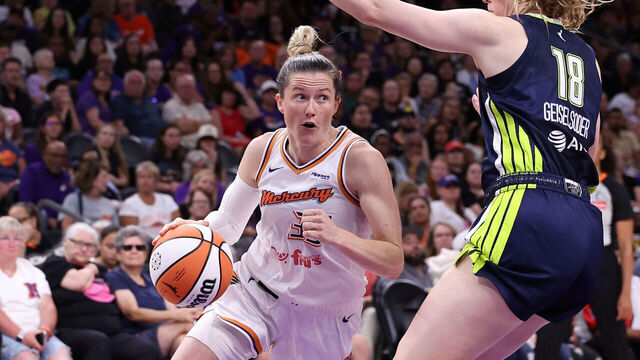 PHOENIX, ARIZONA - JULY 07: Sami Whitcomb #33 of the Phoenix Mercury drives to the basket against Luisa Geiselsoder #18 of the Dallas Wings during the first half at PHX Arena on July 07, 2025 in Phoenix, Arizona.