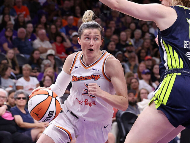 PHOENIX, ARIZONA - JULY 07: Sami Whitcomb #33 of the Phoenix Mercury drives to the basket against Luisa Geiselsoder #18 of the Dallas Wings during the first half at PHX Arena on July 07, 2025 in Phoenix, Arizona.