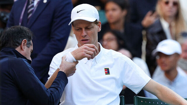 Italy's Jannik Sinner reacts as he receives medical treatment during his men's singles fourth round tennis match against Bulgaria's Grigor Dimitrov on the eighth day of the 2025 Wimbledon Championships at The All England Lawn Tennis and Croquet Club in Wimbledon, southwest London, on July 7, 2025.
