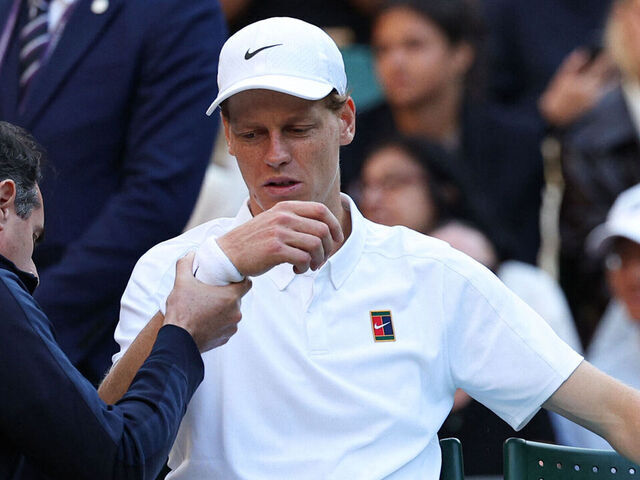 Italy's Jannik Sinner reacts as he receives medical treatment during his men's singles fourth round tennis match against Bulgaria's Grigor Dimitrov on the eighth day of the 2025 Wimbledon Championships at The All England Lawn Tennis and Croquet Club in Wimbledon, southwest London, on July 7, 2025.