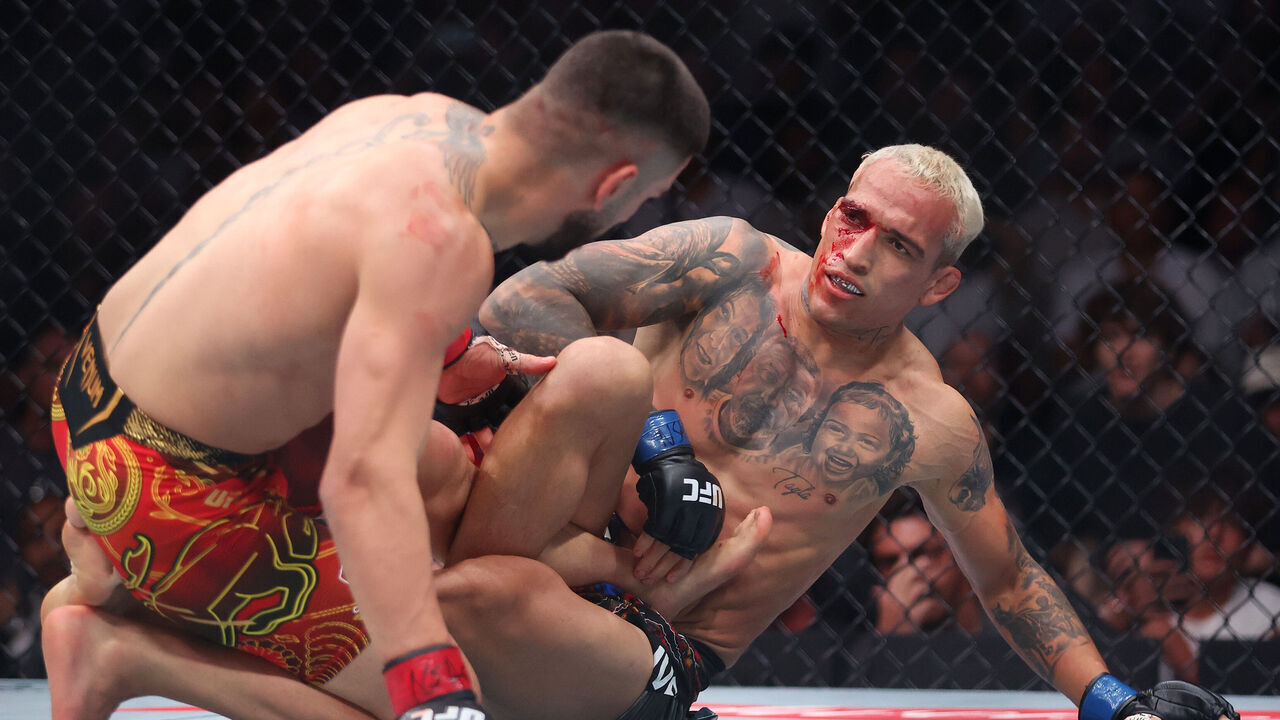 LAS VEGAS, NEVADA - JUNE 28: Charles Oliveira of Brazil and Ilia Topuria of Georgia exchange blows in their lightweight main event title bout during UFC 317 at T-Mobile Arena on June 28, 2025 in Las Vegas, Nevada.