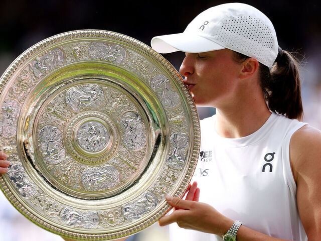 LONDON, ENGLAND - JULY 12: Iga Swiatek of Poland kisses the Ladies’ Singles Trophy following her victory against Amanda Anisimova of United States during the Ladies' Singles Fina on day thirteen of The Championships Wimbledon 2025 at All England Lawn Tennis and Croquet Club on July 12, 2025 in London, England.
