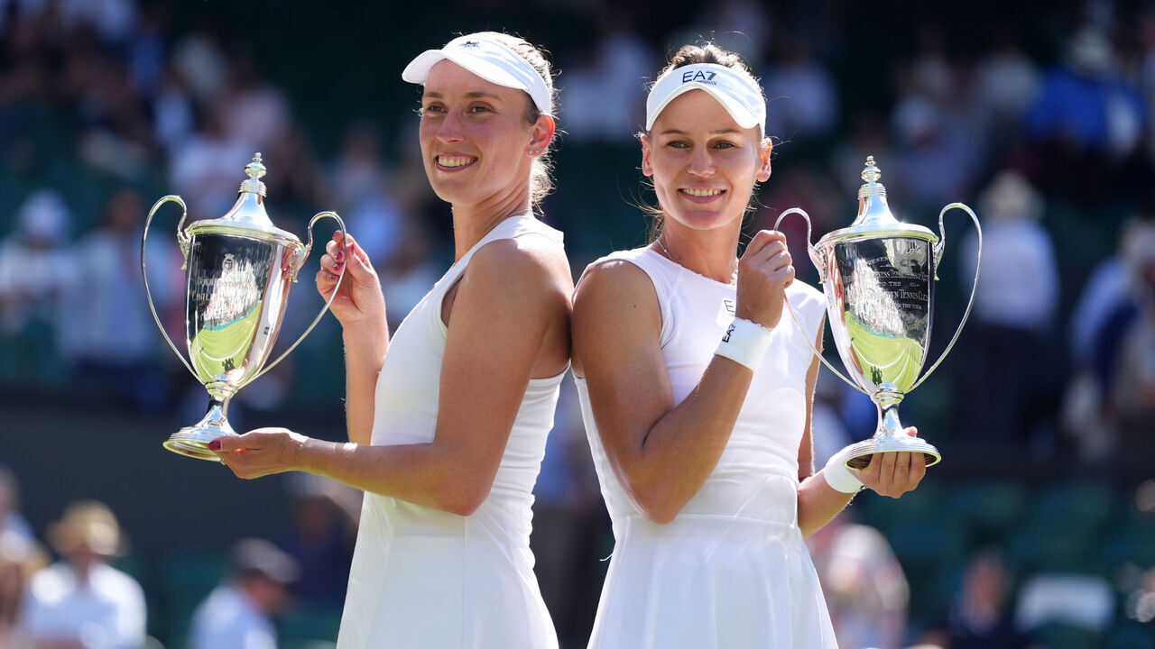 Veronika Kudermetova and Elise Mertens, with their trophies following their victory over Su-Wei Hsieh and Jelena Ostapenko in the Ladies' Doubles Final on day fourteen of the 2025 Wimbledon Championships at the All England Lawn Tennis and Croquet Club, London. Picture date: Sunday July 13, 2025.