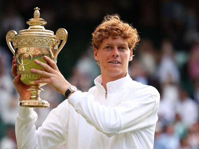 Italy's Jannik Sinner celebrates with the winner's trophy as he poses for pictures following his victory against Spain's Carlos Alcaraz at the end of their men's singles final tennis match on the fourteenth day of the 2025 Wimbledon Championships at The All England Lawn Tennis and Croquet Club in Wimbledon, southwest London, on July 13, 2025.