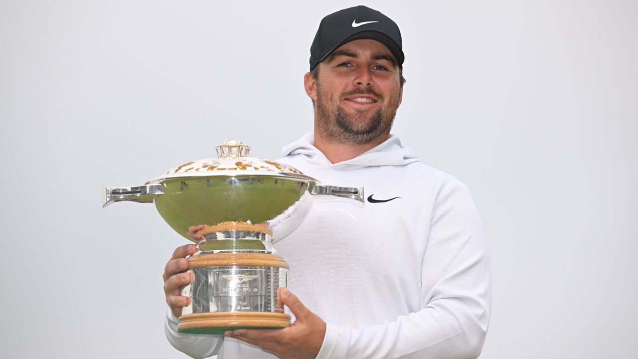 NORTH BERWICK, SCOTLAND - JULY 13: Chris Gotterup of the United States holds the trophy on the 18th green after the final round of Genesis Scottish Open at The Renaissance Club on July 13, 2025 in North Berwick, Scotland.
