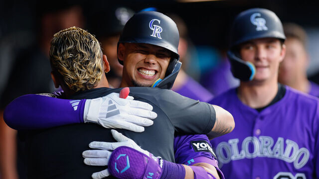 DENVER, CO - JULY 19: Ezequiel Tovar #14 of the Colorado Rockies smiles and is congratulated by Orlando Arcia #11 in the dugout after hitting a three-run home run as Mickey Moniak #22 looks on in the fifth inning against the Minnesota Twins at Coors Field on July 19, 2025 in Denver, Colorado.