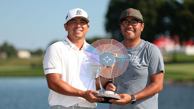 BLAINE, MINNESOTA - JULY 27: Kurt Kitayama of the United States poses with the Elemental Swing trophy and his caddie Daniel Kitayama after putting in to win on the 18th green during the final round of the 3M Open 2025 at TPC Twin Cities on July 27, 2025 in Blaine, Minnesota.