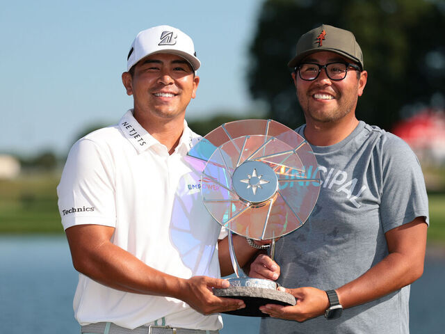 BLAINE, MINNESOTA - JULY 27: Kurt Kitayama of the United States poses with the Elemental Swing trophy and his caddie Daniel Kitayama after putting in to win on the 18th green during the final round of the 3M Open 2025 at TPC Twin Cities on July 27, 2025 in Blaine, Minnesota.