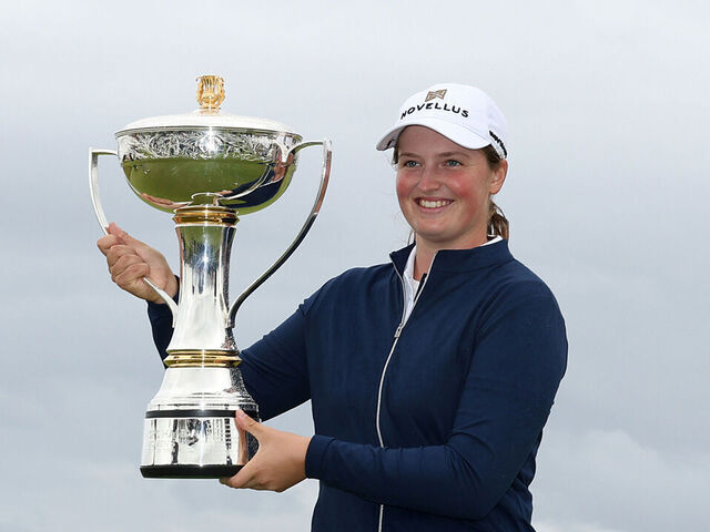 TROON, SCOTLAND - JULY 27: Lottie Woad of England poses with the trophy on the 18th green following victory in the final round of the ISPS HANDA Women's Scottish Open 2025 at Dundonald Links Golf Course on July 27, 2025 in Troon, Scotland.