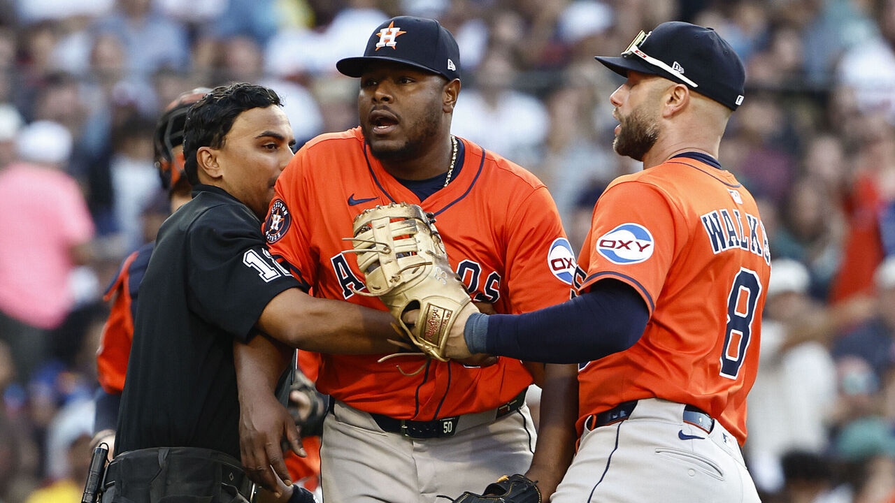 BOSTON, MA - AUGUST 2: Umpire Gerry Davis #12 and Christian Walker #8 of the Houston Astros hold back pitcher Héctor Neris #50 after he thought the Boston Red Sox were stealing signs during the seventh inning at Fenway Park on August 2, 2025 in Boston, Massachusetts.