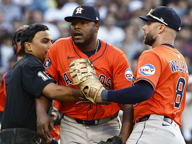 BOSTON, MA - AUGUST 2: Umpire Gerry Davis #12 and Christian Walker #8 of the Houston Astros hold back pitcher Héctor Neris #50 after he thought the Boston Red Sox were stealing signs during the seventh inning at Fenway Park on August 2, 2025 in Boston, Massachusetts.