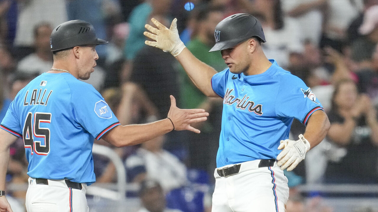 MIAMI, FLORIDA - AUGUST 03: Jakob Marsee #87 of the Miami Marlins celebrates with third base coach Blake Lalli #45 after hitting a triple during the seventh inning against the New York Yankees at loanDepot park on August 03, 2025 in Miami, Florida.