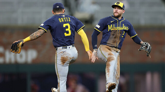 ATLANTA, GEORGIA - AUGUST 05: Joey Ortiz #3 and Brice Turang #2 of the Milwaukee Brewers react after their 7-2 win over the Atlanta Braves at Truist Park on August 05, 2025 in Atlanta, Georgia.