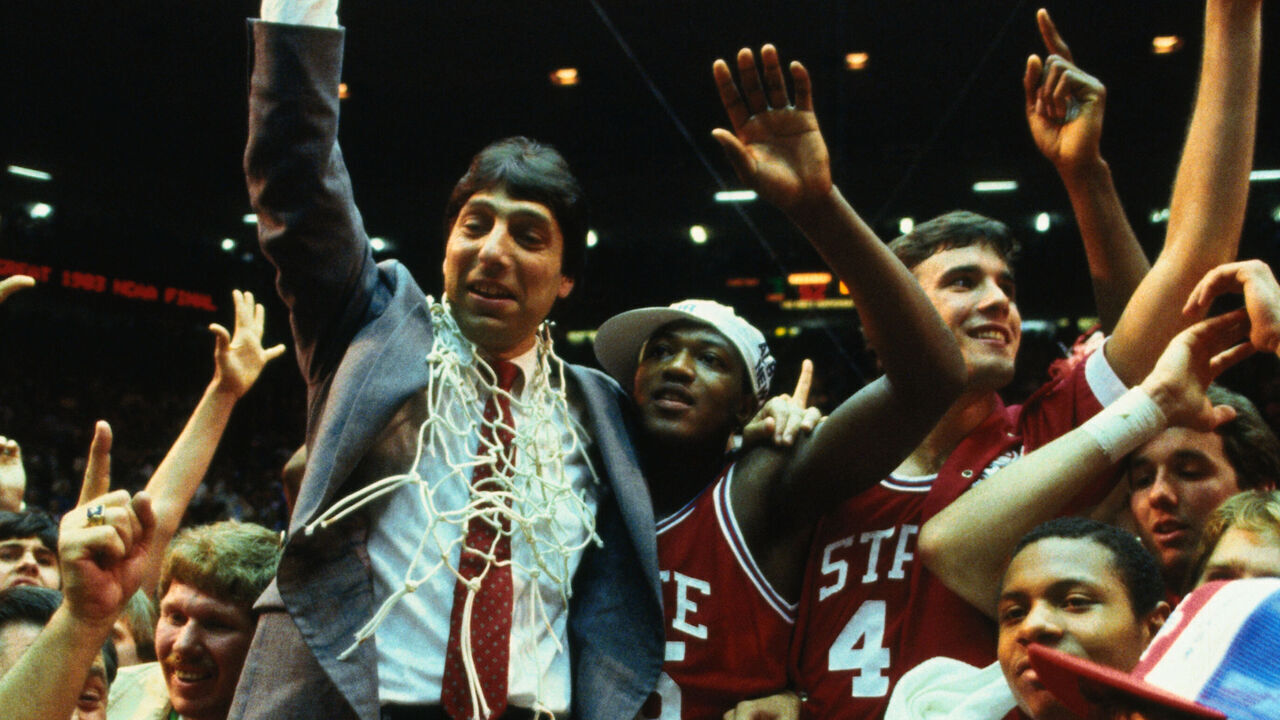 (Original Caption) Albuquerque, New Mexico: North Carolina State's coach Jim Valvano gives the #1 winning sign as he stand with his winning team at the NCAA Final Four championship game. North Carolina defeated Houston 54-52 in the championship game.