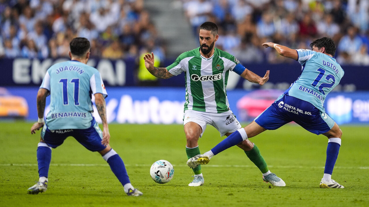 MALAGA, SPAIN - AUGUST 09: Francisco 'Isco' Alarcon of Real Betis and Carlos Dotor of Malaga CF in action during XXXV Costa del Sol Trophy, football match played between Malaga CF and Real Betis at La Rosaleda Stadium on August 9, 2025, in Malaga, Spain.