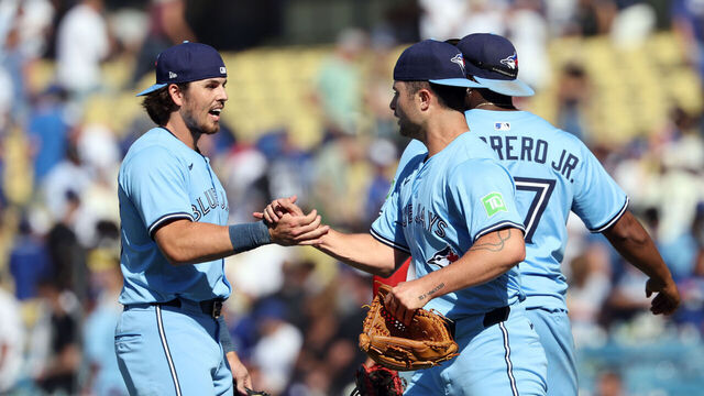 LOS ANGELES, CALIFORNIA - AUGUST 10: Relief pitcher Mason Fluharty #68 of the Toronto Blue Jays celebrates with Addison Barger #47 and Vladimir Guerrero Jr. #27 after closing the game 5-4 against Los Angeles Dodgers, avoiding a sweep at Dodger Stadium on August 10, 2025 in Los Angeles, California.