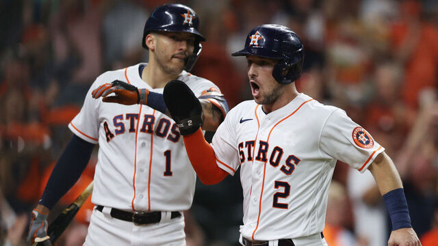 HOUSTON, TEXAS - OCTOBER 22: Alex Bregman #2 of the Houston Astros celebrates with Carlos Correa #1 after scoring a run on a double by Yordan Alvarez #44 during the first inning in Game Six of the American League Championship Series against the Boston Red Sox at Minute Maid Park on October 22, 2021 in Houston, Texas.