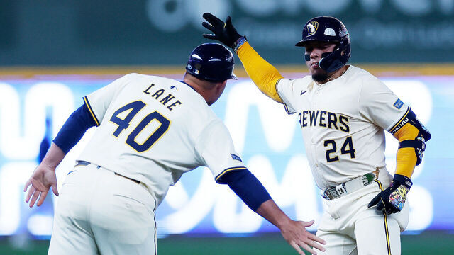 MILWAUKEE, WISCONSIN - JULY 30: William Contreras #24 of the Milwaukee Brewers is congratulate by third base coach Jason Lane #40 of the Milwaukee Brewers after hitting a solo home run in the first inning against the Chicago Cubs at American Family Field on July 30, 2025 in Milwaukee, Wisconsin.
