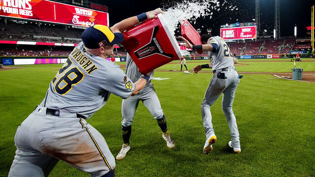 CINCINNATI, OHIO - AUGUST 15: Andrew Vaughn #28 and Caleb Durbin #21 of the Milwaukee Brewers attempt to dump ice on teammate Christian Yelich #22 after the game against the Cincinnati Reds at Great American Ball Park on August 15, 2025 in Cincinnati, Ohio. Milwaukee Brewers won 10-8.