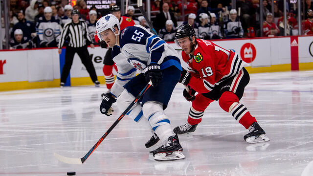 CHICAGO, IL - APRIL 01: Winnipeg Jets center Mark Scheifele (55) controls the puck against Chicago Blackhawks center Jonathan Toews (19) during a game between the Winnipeg Jets and the Chicago Blackhawks on April 1, 2019, at the United Center in Chicago, IL.