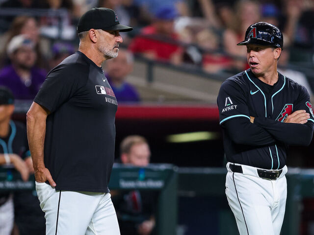 PHOENIX, ARIZONA - AUGUST 09: Manager Torey Lovullo #17 of the Arizona Diamondbacks and third base coach Shaun Larkin #88 confer during the first inning of a game against the Colorado Rockies at Chase Field on August 09, 2025 in Phoenix, Arizona.