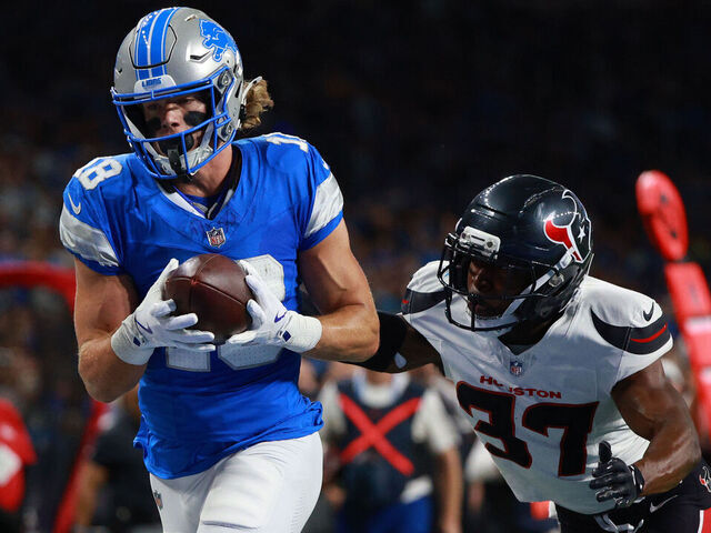 DETROIT,MICHIGAN-AUGUST 23: Detroit Lions wide receiver Isaac TeSlaa #18 scores a touchdown while guarded by Houston Texans cornerback D'Angelo Ross #37 during the first half of an NFL football game between the Houston Texans and the Detroit Lions in Detroit, Michigan USA, on Saturday, August 23, 2025