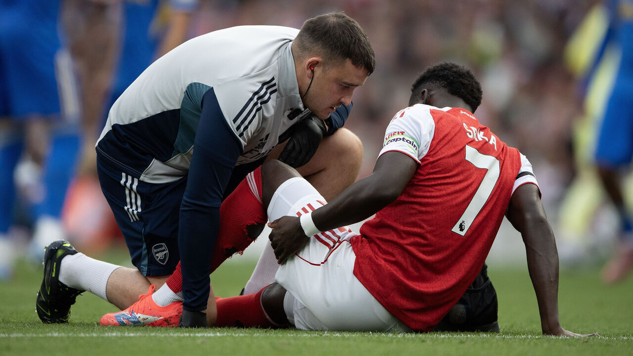 LONDON, ENGLAND - AUGUST 23: Bukayo Saka of Arsenal holds his left hamstring as he receives medical attention during the Premier League match between Arsenal and Leeds United at Emirates Stadium on August 23, 2025 in London, England.