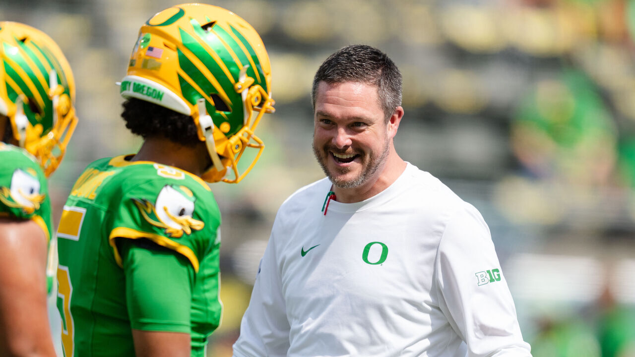 EUGENE, OREGON - AUGUST 30: Head Coach Dan Lanning of the Oregon Ducks talks with quarterback Dante Moore #5 during warm-up before the game against the Montana State Bobcats at Autzen Stadium on August 30, 2025 in Eugene, Oregon.