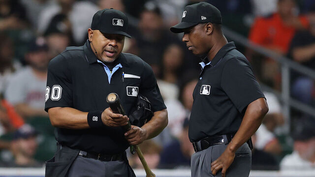 HOUSTON, TEXAS - SEPTEMBER 04: Umpire Adrian Johnson #80 and umpire Ramon De Jesus #18 examine a bat belonging to Taylor Trammell #26 of the Houston Astros during the ninth inning against the New York Yankees at Daikin Park on September 04, 2025 in Houston, Texas.