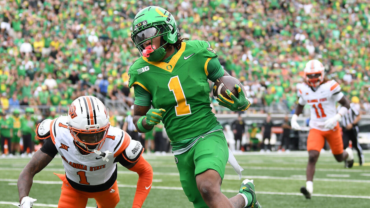 EUGENE, OR - SEPTEMBER 06: Oregon Ducks wide receiver Dakorien Moore (1) scores on a 25-yard touchdown run against Oklahoma State Cowboys corner back JK Johnson (1) in the second quarter during a college football game between the Oklahoma State Cowboys and the Oregon Ducks on September 6, 2025, at Autzen Stadium in Eugene, Oregon.