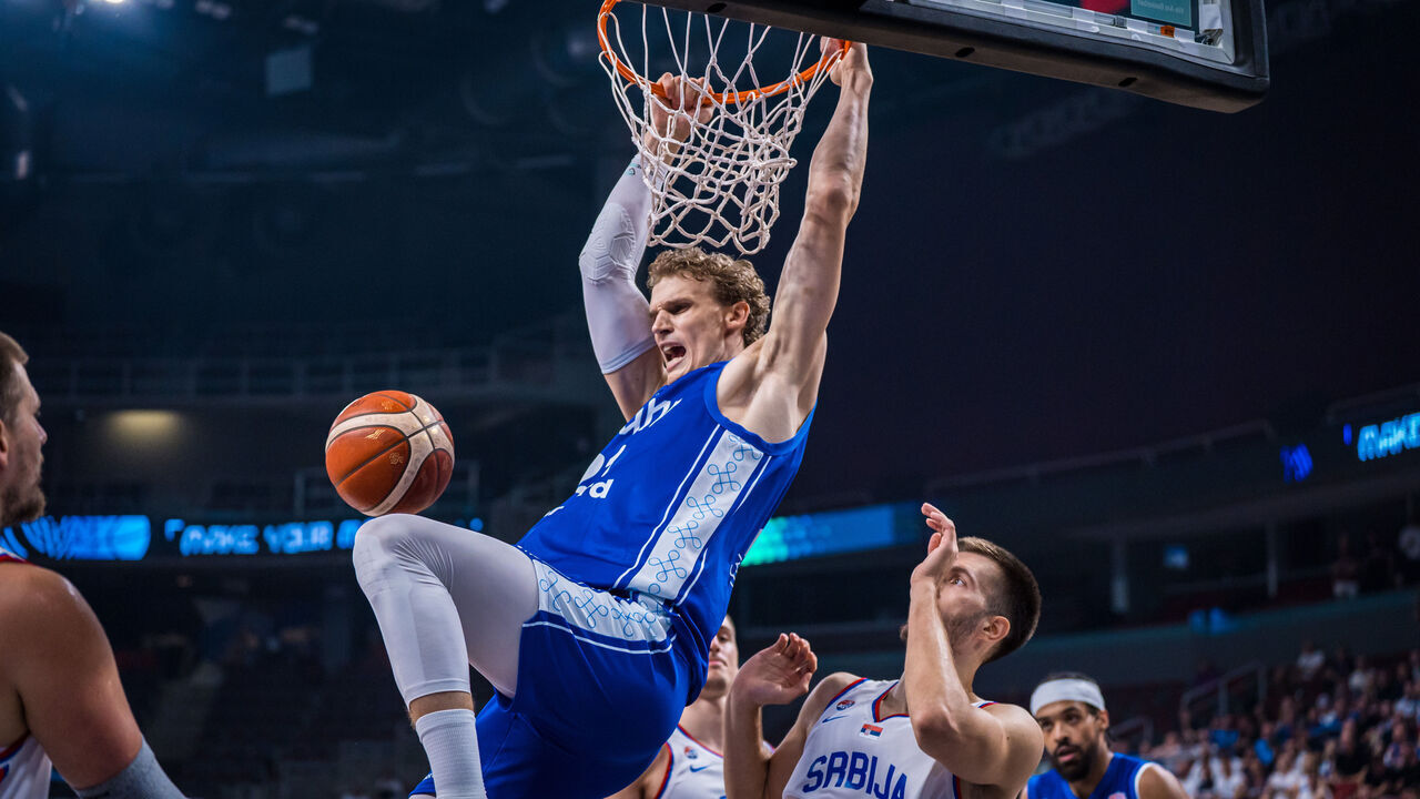 RIGA, LATVIA - SEPTEMBER 06: Lauri Markkanen of Finland hangs on the rim in celebration after a thunderous dunk during the Round of 16 FIBA Eurobasket 2025 game between Serbia and Finland at Arena Riga on September 06, 2025 in Riga, Latvia.