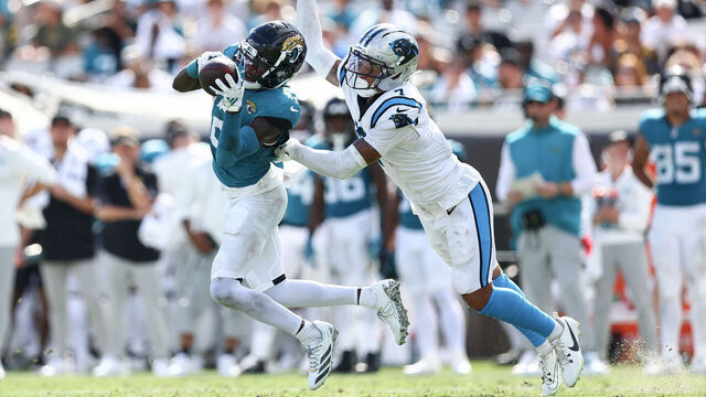 JACKSONVILLE, FLORIDA - SEPTEMBER 07: Travis Hunter #12 of the Jacksonville Jaguars catches a pass in front of Tre'von Moehrig #7 of the Carolina Panthers during the fourth quarter at EverBank Stadium on September 07, 2025 in Jacksonville, Florida.