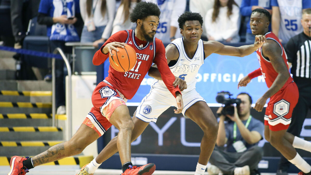 PROVO, UT - DECEMBER 11: Mykell Robinson #11 of the Fresno State Bulldogs drives to the basket against Kanon Catchings #6 of the Brigham Young Cougars during the second half of their game at the Marriott Center on December 11, 2024 in Provo, Utah.