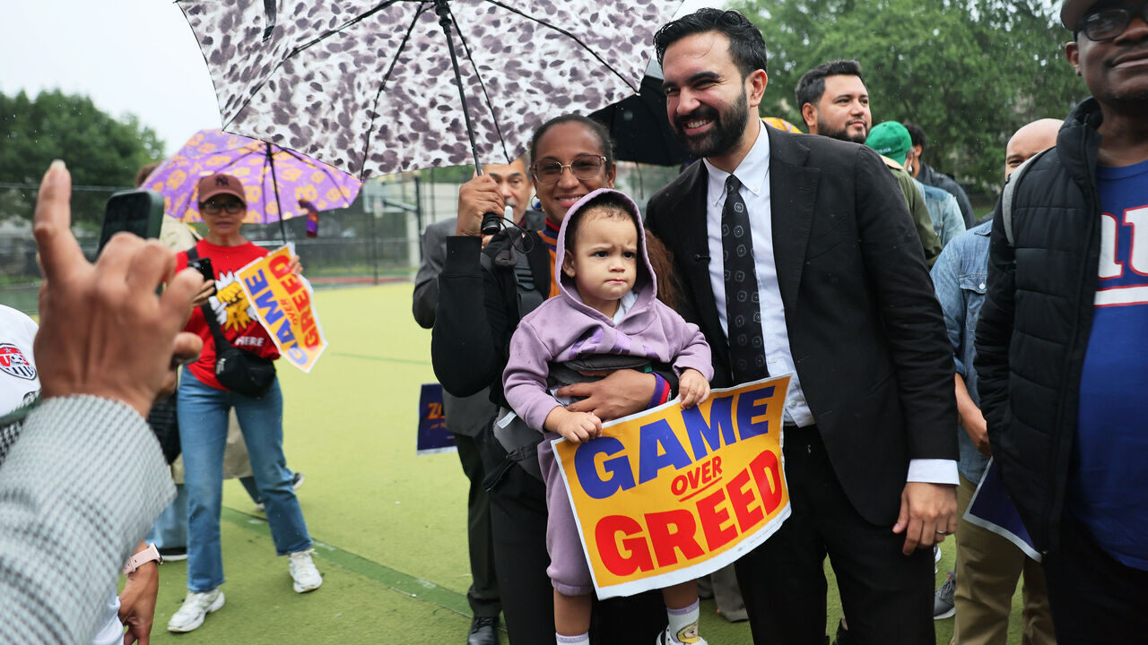 NEW YORK, NEW YORK - SEPTEMBER 10: Yomy Lopez holds her daughter as she poses for a photo with New York Mayoral Candidate Zohran Mamdani after a press conference at St. James Park on September 10, 2025 in the Bronx borough in New York City. Mamdani held a press conference announcing his campaign’s petition urging FIFA to drop dynamic ticket pricing for next summer’s World Cup, co-hosted by the United States, Canada and Mexico, with the final at MetLife Stadium. A recent Sienna College poll shows that Mamdani is holding a 22-point lead in the race for mayor of New York City ahead of NYC Mayoral Candidate Former Governor Andrew and incumbent NYC Mayor Eric Adams.