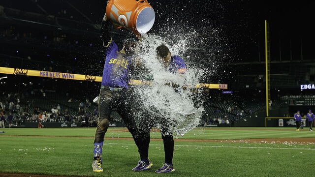 SEATTLE, WASHINGTON - SEPTEMBER 11: J.P. Crawford #3 of the Seattle Mariners pours water on Harry Ford #5 after the game against the Los Angeles Angels at T-Mobile Park on September 11, 2025 in Seattle, Washington. The Seattle Mariners won 7-6 in 12 innings.