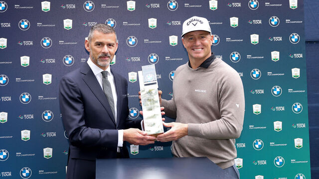 VIRGINIA WATER, ENGLAND - SEPTEMBER 14: Alex Noren of Sweden is presented with the trophy in the flash recording area by David George, CEO of BMW UK & Ireland on day four of the BMW PGA Championship 2025 at Wentworth Golf Club on September 14, 2025 in Virginia Water, England.