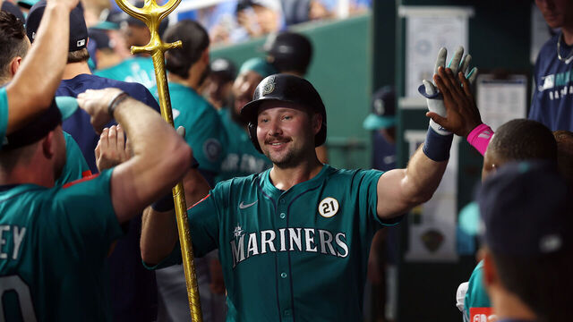 KANSAS CITY, MISSOURI - SEPTEMBER 16: Cal Raleigh #29 of the Seattle Mariners is congratulated by teammates in the dugout after hitting a home run during the third inning of the game against the Kansas City Royals at Kauffman Stadium on September 16, 2025 in Kansas City, Missouri.