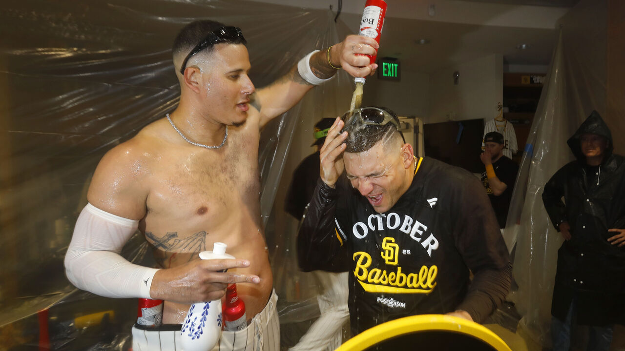 San Diego, CA - September 22: Manny Machado #13 of the San Diego Padres celebrates with Jose Iglesias #7 in the clubhouse after beating the Milwaukee Brewers to secure a playoff spot at Petco Park on September 22, 2025 in San Diego, CA. (K.C. Alfred / The San Diego Union-Tribune via Getty Images)